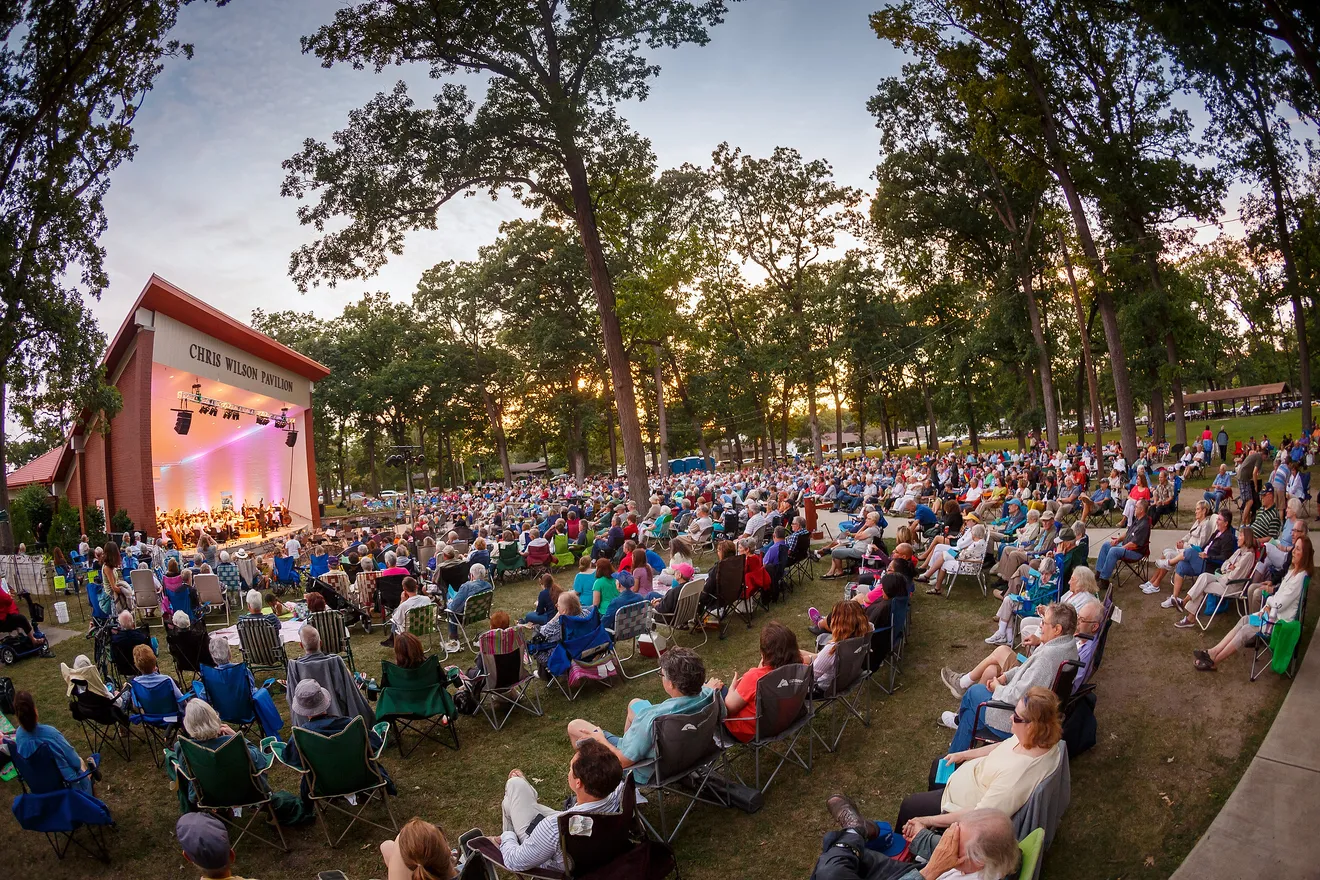 Large crowd seated in lawn chairs enjoying a concert at Potawatomi Park